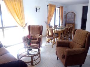 ein Wohnzimmer mit Möbeln, einem Tisch und Stühlen in der Unterkunft El Capistrano in Nerja