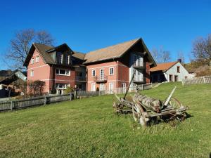 a large house with a wooden cart in a field at Landhaus zur Schmiede in Abtsroda