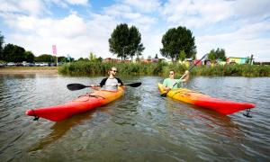 two men in kayaks on a river in the water at Camping Zeeburg Amsterdam in Amsterdam