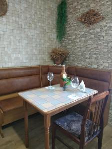 a table with two wine glasses on a couch at Апартаменти в новому будинку біля Либідь Плаза-Квартал in Khmelʼnytsʼkyy +21 photos