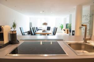 een keuken met een tablet op een aanrecht naast een wastafel bij The City Suite - Luxuswohnung in Kempten