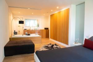 a bedroom with a bed and a bathroom with a tub at The City Suite - Luxuswohnung in Kempten