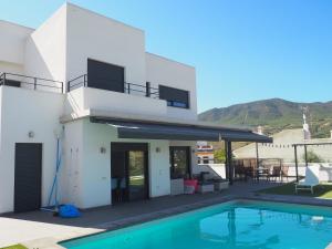 una villa con piscina e montagne sullo sfondo di La Casa en el Valle, 5 bedroom villa with private pool a Melegis