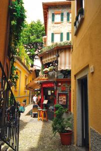 een smalle straat met een restaurant in een gebouw bij Locanda Barchetta - Room Rental in Bellagio