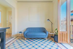 a blue couch sitting in a living room at Mosaiko Homes Catedral Granada in Granada