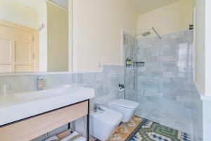 a bathroom with a toilet and a sink and a shower at Mosaiko Homes Catedral Granada in Granada