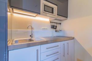 a kitchen with a sink and a microwave at Mosaiko Homes Catedral Granada in Granada
