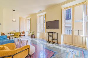 un soggiorno con divano e TV di Mosaiko Homes Catedral Granada a Granada