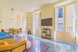 a living room with a couch and a tv at Mosaiko Homes Catedral Granada in Granada
