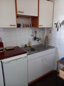 a kitchen with white cabinets and a sink at Soleil et Montagne Bâtiment E in Les Angles