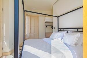 a bedroom with a canopy bed with white pillows at Mosaiko Homes Catedral Granada in Granada +37 photos