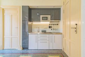 a white kitchen with a sink and a microwave at Mosaiko Homes Catedral Granada in Granada