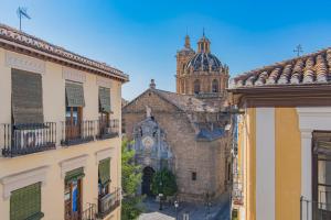 an old building with a clock tower in the background at Mosaiko Homes Catedral Granada in Granada