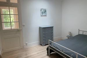 a bedroom with a bed and a dresser and a door at Hyper centre Maison le petit Bouchon in Ay