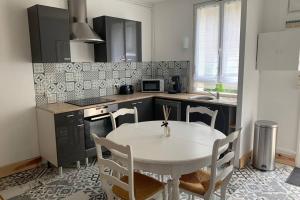 a kitchen with a white table and chairs in it at Hyper centre Maison le petit Bouchon in Ay +21 photos