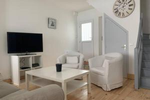 a living room with a tv and two chairs and a table at Hyper centre Maison le petit Bouchon in Ay