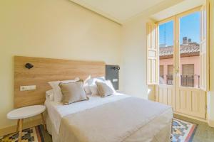 a bedroom with a large bed and a large window at Mosaiko Homes Catedral Granada in Granada