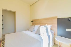 a bedroom with a white bed and a sink at Mosaiko Homes Catedral Granada in Granada