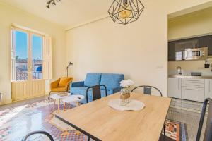a living room with a table and a blue chair at Mosaiko Homes Catedral Granada in Granada