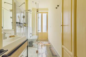 a bathroom with a sink and a toilet and a door at Mosaiko Homes Catedral Granada in Granada