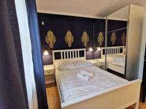 a bedroom with a large white bed with mirrors at Apartamenty nad potokiem in Zakopane