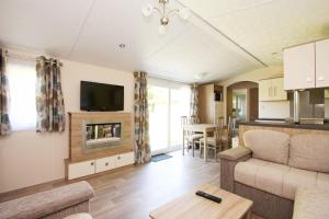 a living room with a couch and a television at schönes Chalet Tinyhouse in Ostseenähe 13km - sehr ruhige Dorflage in Vogtshagen