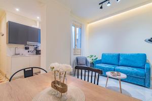 a living room with a blue couch and a table at Mosaiko Homes Catedral Granada in Granada