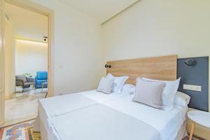 a bedroom with a large white bed with white pillows at Mosaiko Homes Catedral Granada in Granada