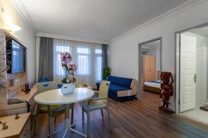 a living room with a table and a blue couch at Angora Apart Hotel in Alanya
