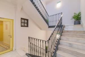 a staircase in a house with a yellow door at Mosaiko Homes Catedral Granada in Granada