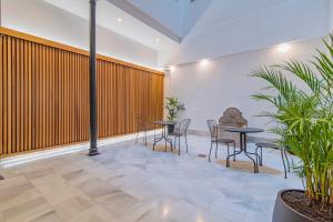 a meeting room with tables and chairs and plants at Mosaiko Homes Catedral Granada in Granada