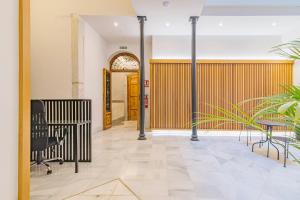a hallway with a wooden fence and chairs and a door at Mosaiko Homes Catedral Granada in Granada