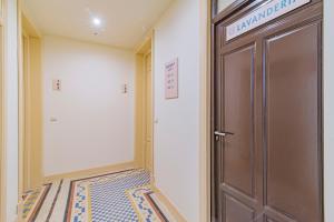 a hallway with a door with a sign on it at Mosaiko Homes Catedral Granada in Granada