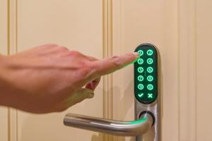 a person pressing a green door handle with their hand at Mosaiko Homes Catedral Granada in Granada