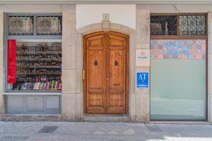 a building with a wooden door in front of a store at Mosaiko Homes Catedral Granada in Granada