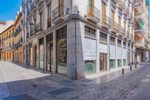 a street in a city with a building with windows at Mosaiko Homes Catedral Granada in Granada