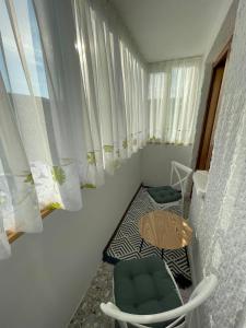 a small room with a table and chairs and curtains at Like Home - Cozy & Quite in Piatra Neamţ