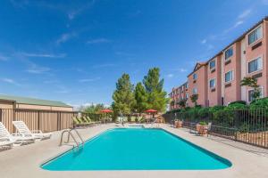 a swimming pool with chairs and a building at Days Inn by Wyndham Camp Verde Arizona in Camp Verde