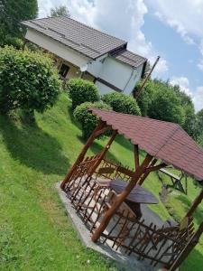 - une table de pique-nique et des chaises en face d'une maison dans l'établissement Casa de vacanța Marin, à Arpaşu de Sus