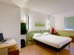 ルゼにあるIbis Budget Nantes Reze Aeroportのベッドルーム1室(ベッド1台、ノートパソコン付きのデスク付)