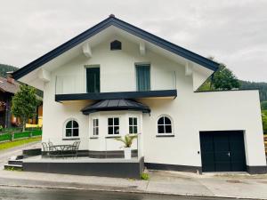 a white house with a black roof at Townville Chalet´s in Flachau