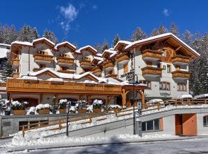 a large building with snow on top of it at Hotel Madonna delle Nevi in Folgarida