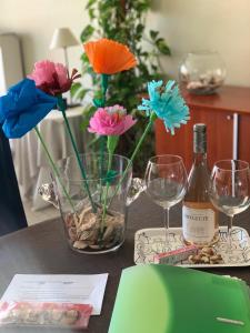 a table with flowers and a bottle of wine and glasses at ORCHIS Duplex in Knokke-Heist