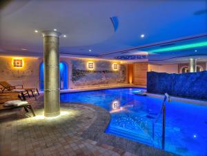 a swimming pool in a house with blue lighting at Hotel Madonna delle Nevi in Folgarida