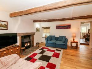 a living room with a couch and a fireplace at The Cottage in Hayfield