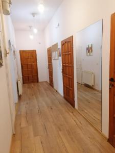 Cette chambre dispose de portes et d'un couloir revêtu de parquet. dans l'établissement Hostel Tulip - Pokój 1 ze wspólną łazienką i kuchnią, à Szczecin
