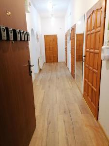 korytarz z drewnianymi drzwiami i korytarz z korytarzem w obiekcie Hostel Tulip - Pokój 1 ze wspólną łazienką i kuchnią w Szczecinie