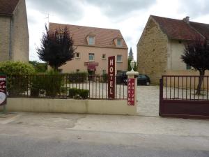 une porte avec un panneau devant un bâtiment dans l'établissement Hôtel A La Renommée, à Saint-Père