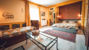 a bedroom with a bed and a couch and a table at GITE COEUR DE NATURE in Abergement-le-Grand