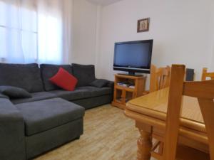 een woonkamer met een bank en een flatscreen-tv bij Cecilia in Riumar